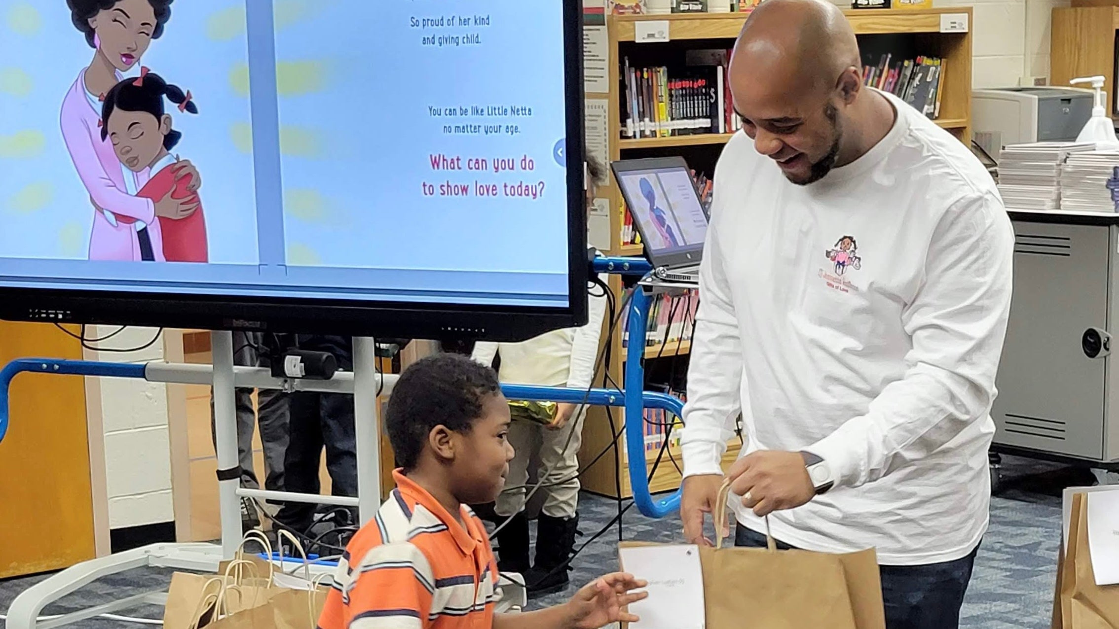 Mike Brown handing a Gifts of Love package to a student